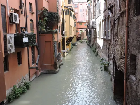 Canal di Reno coulant entre des maisons aux façades ocre et des balcons fleuris