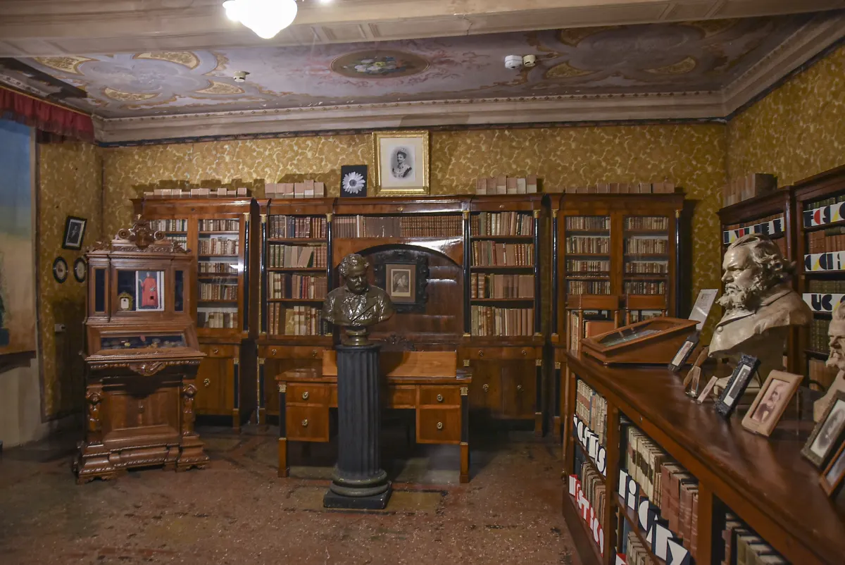 Bibliothèque de Giosuè Carducci avec ses rayonnages de bois, son bureau et un buste