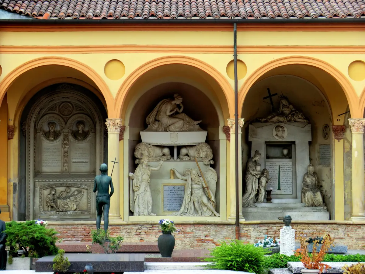 Arcades jaunes du cloître de la Certosa abritant des monuments funéraires sculptés