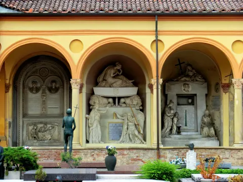 Arcades jaunes du cloître de la Certosa abritant des monuments funéraires sculptés