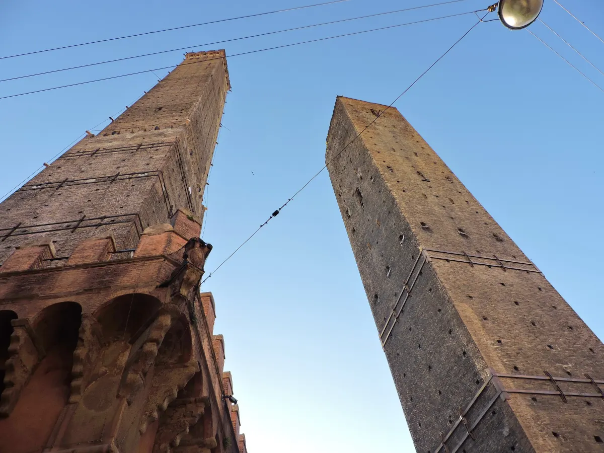 Les tours Garisenda et Asinelli vues d’en bas contre un ciel bleu