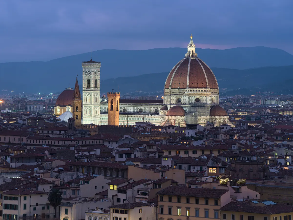 La cathédrale de Florence et son dôme illuminés la nuit au-dessus des toits