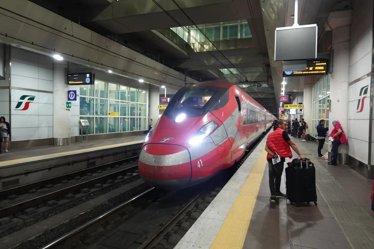 Train à grande vitesse rouge à quai dans la gare souterraine de Bologna Centrale