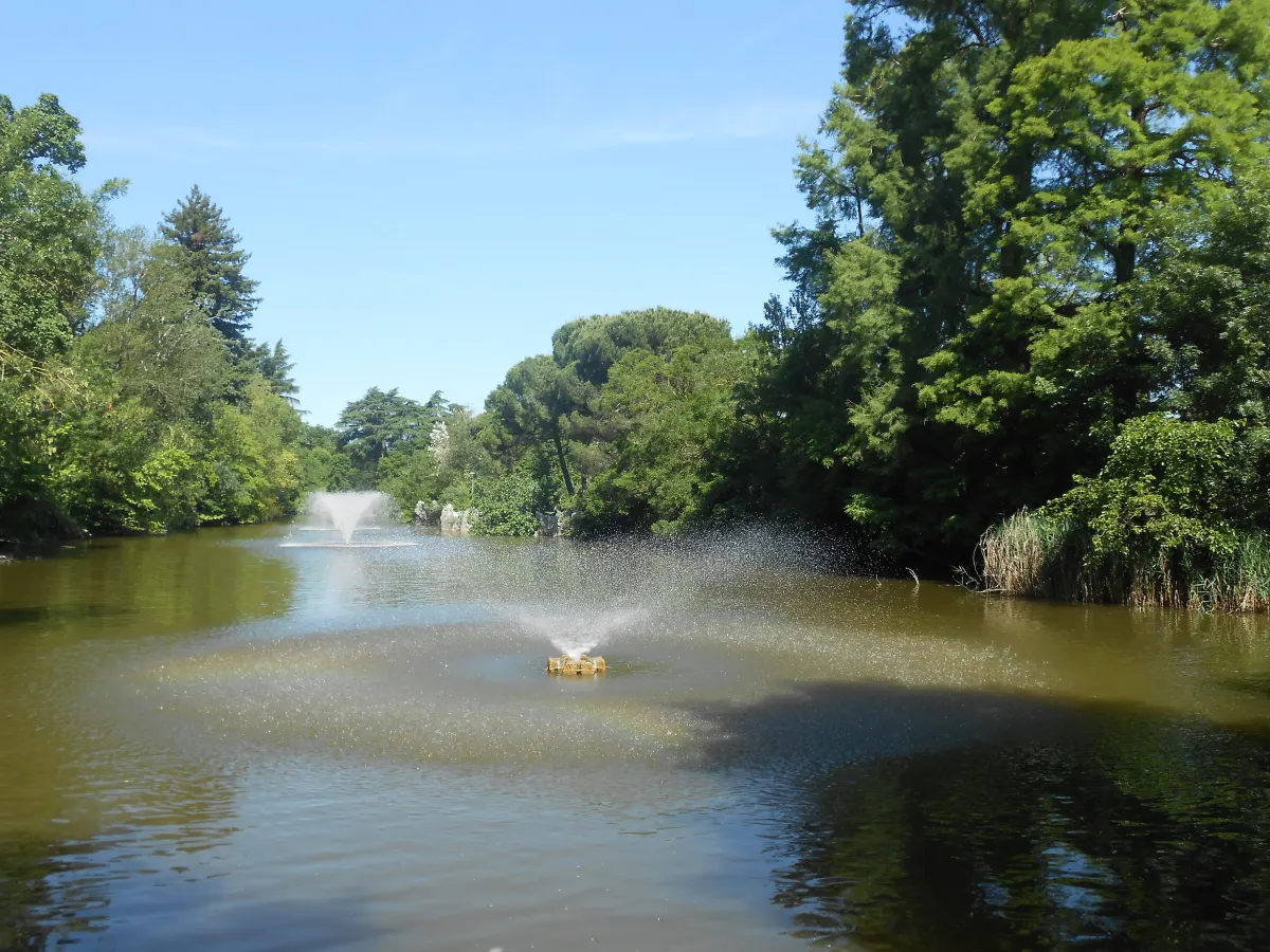 Lac des Giardini Margherita avec son jet d’eau, entouré de grands arbres