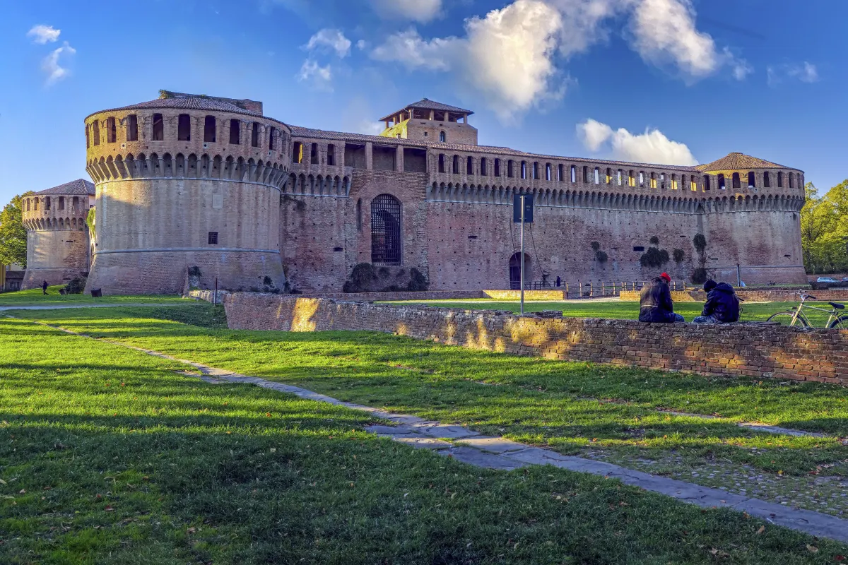 La Rocca Sforzesca d’Imola, forteresse de briques à tours rondes, au-delà d’une pelouse