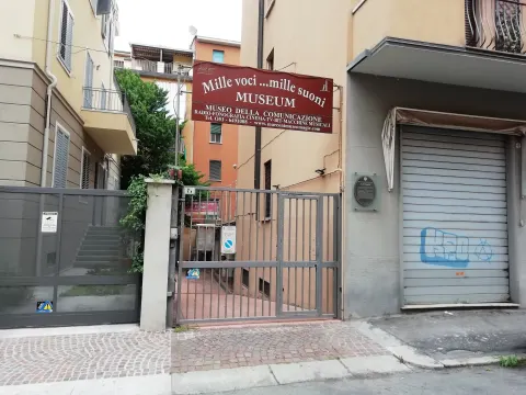 Entrée du musée de la communication avec son enseigne, dans une rue résidentielle