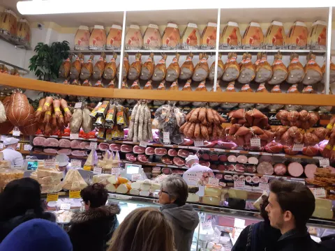 Jambons, saucisses et mortadelles suspendus en rangées dans une charcuterie de Bologne