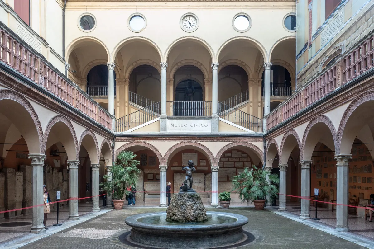 Cour intérieure à arcades du musée archéologique civique avec sa fontaine et ses vitrines