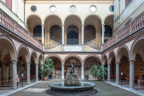 Cour intérieure à arcades du musée archéologique civique avec sa fontaine et ses vitrines