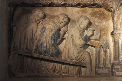 Détail sculpté d’un sarcophage médiéval montrant des étudiants assis à leurs pupitres
