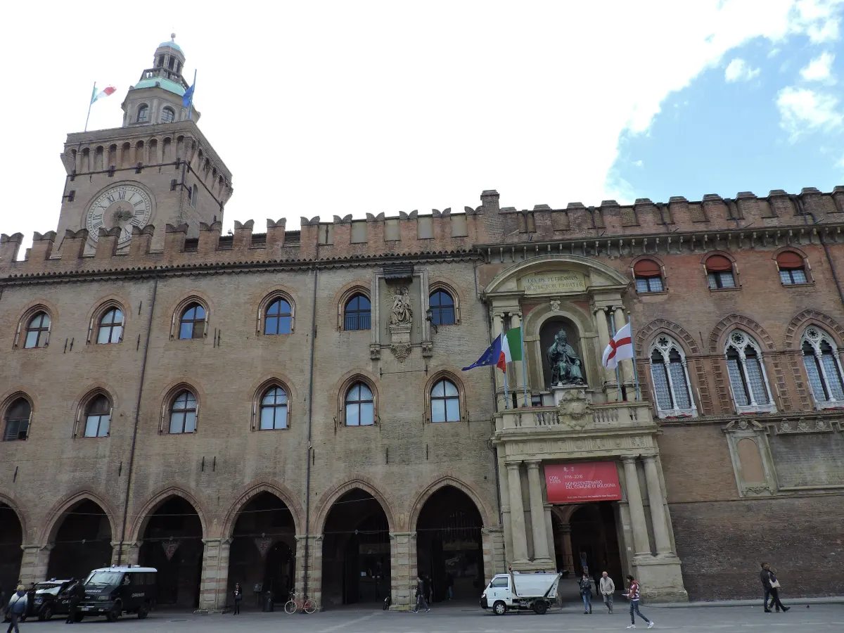 Façade crénelée en brique du Palazzo d’Accursio vue depuis la Piazza Maggiore