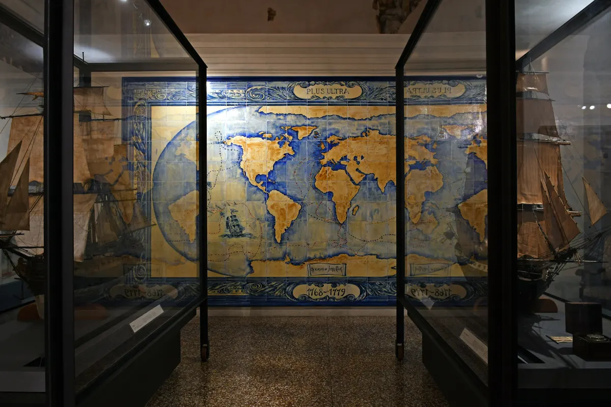 Salle du musée de Palazzo Poggi avec une grande carte du monde ancienne et des vitrines