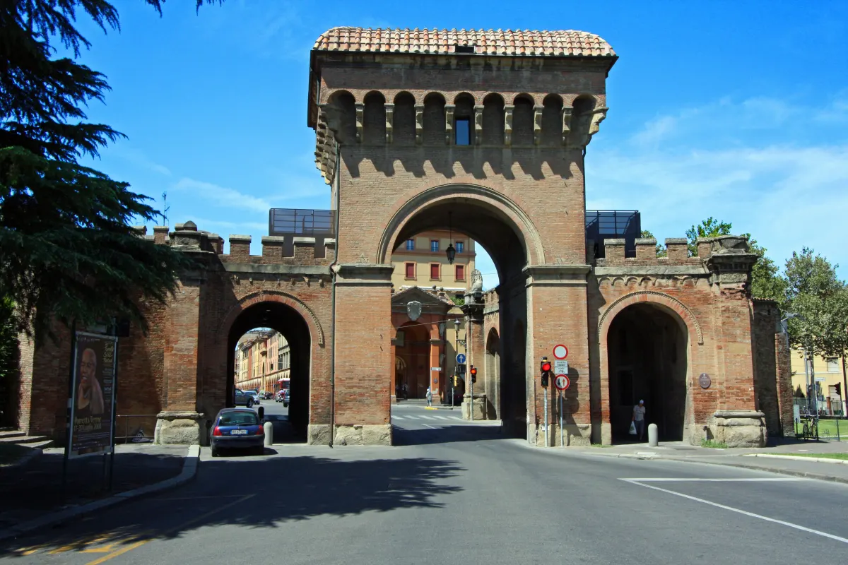 Porta Saragozza, porte crénelée en brique flanquée de deux tours, sous un ciel bleu