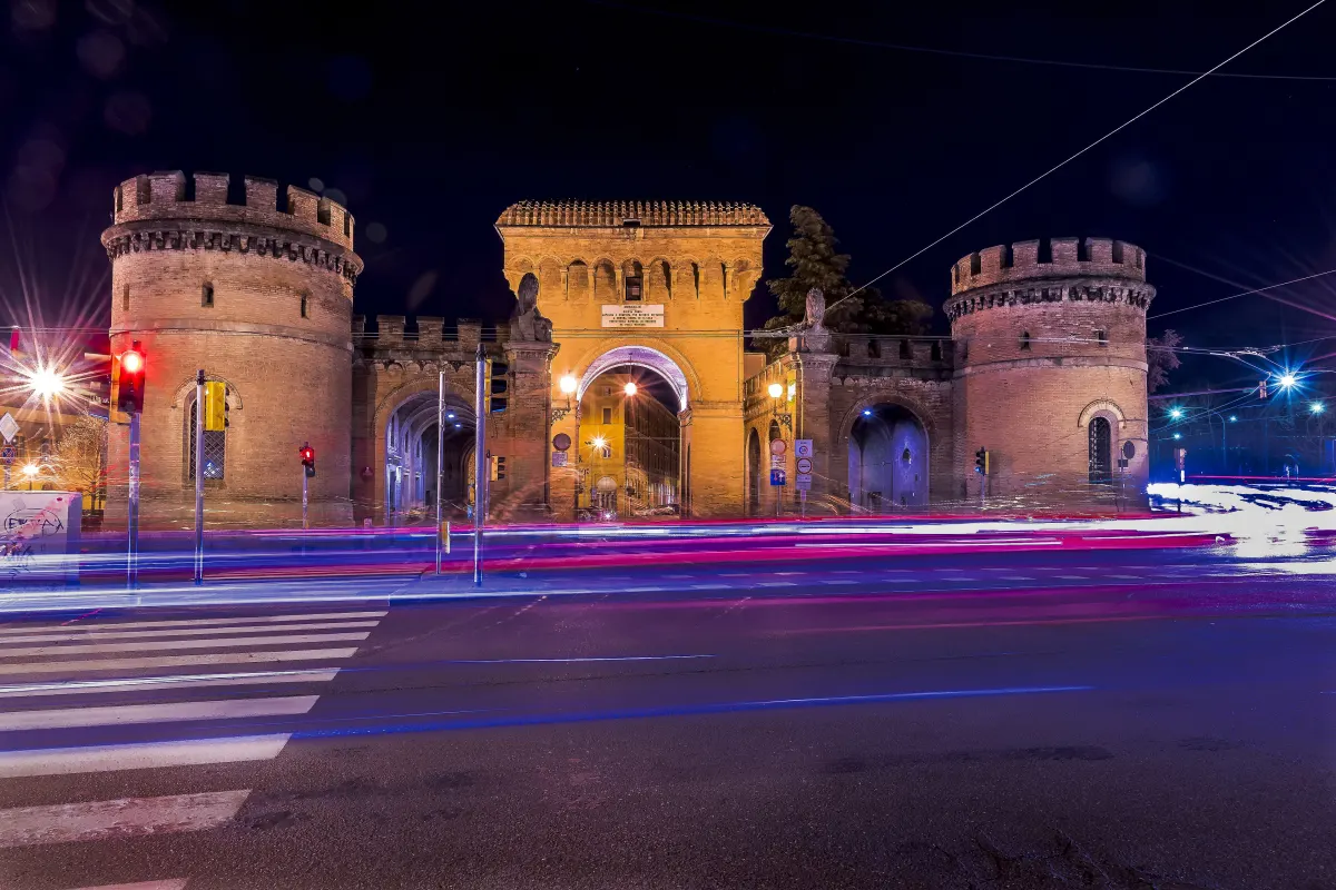 Porta Saragozza illuminée la nuit, traînées lumineuses de la circulation