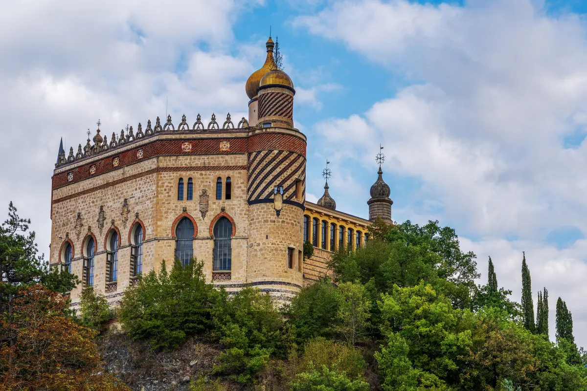Le château de la Rocchetta Mattei, tours crénelées et coupole, au-dessus des arbres