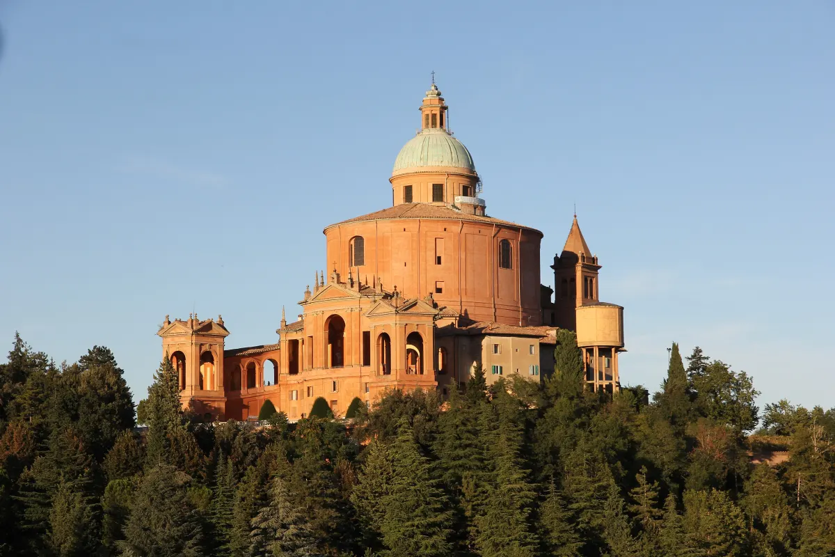 Le sanctuaire de San Luca au sommet de la colline boisée, au soleil couchant